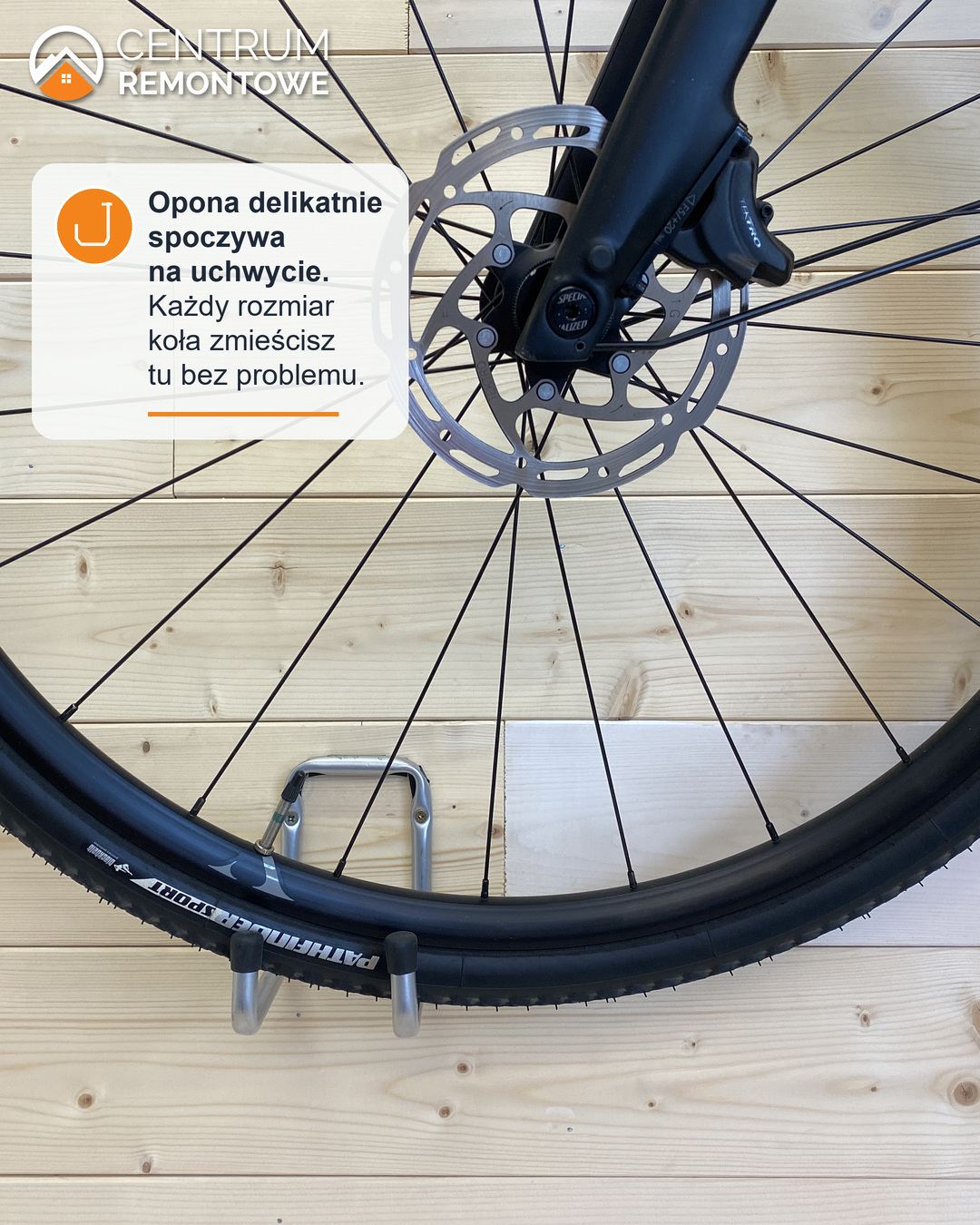Przednie koło roweru oparte oponą na podwójnym haku na ozdobnej drewnianej ścianie w domu