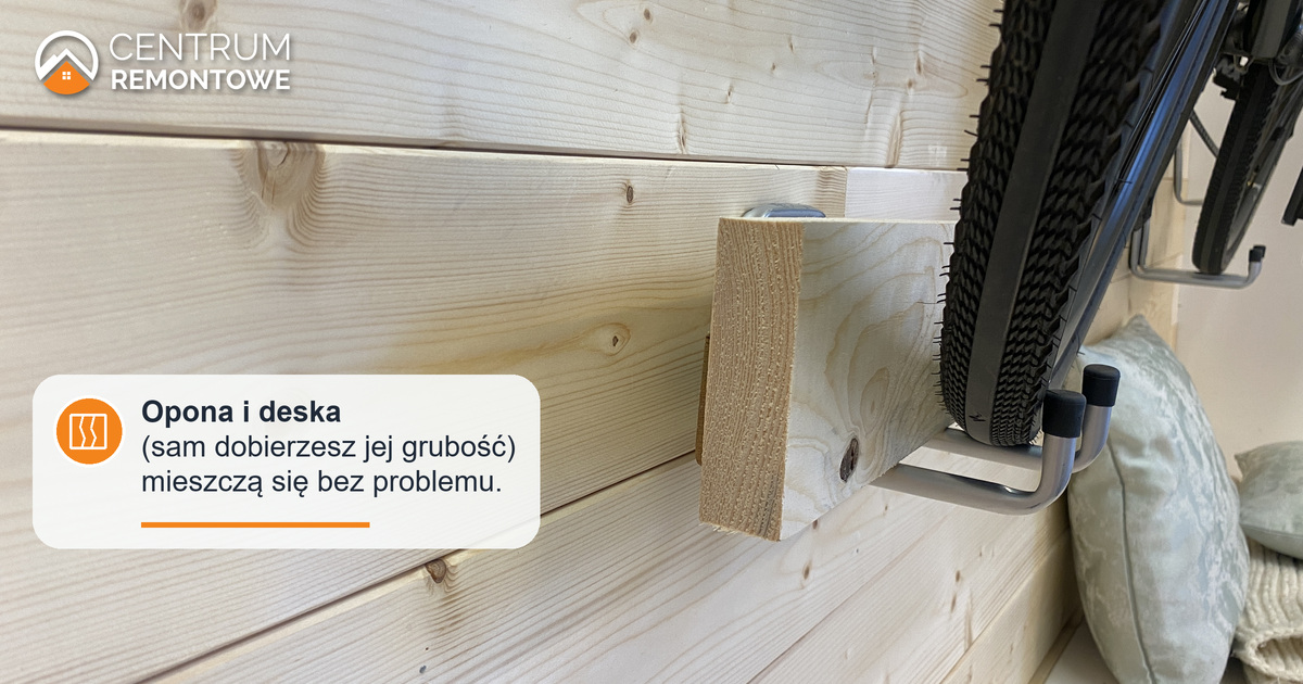 Drewniana deseczka i opona roweru razem na podwójnym haku. Grubość deski można dobrać do opony, którą użytkownik umieści na stojaku.