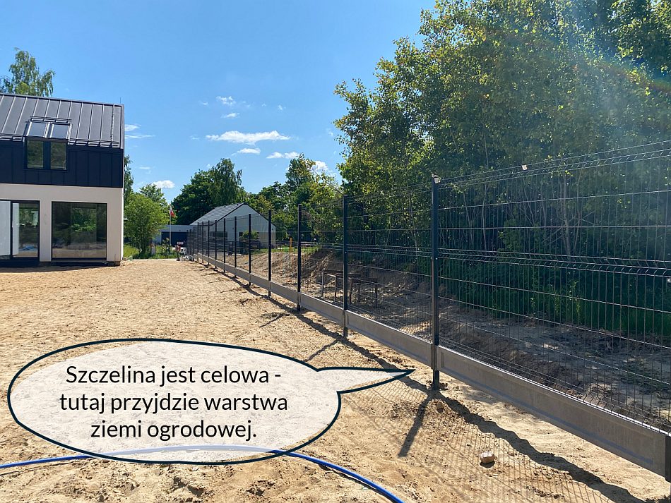 Płot panelowy wzniesiony na działce budowlanej. Pod spodem pozostawiona szczelina, ponieważ poziom gruntu zostanie podniesiony po nawiezieniu ziemi ogrodowej.